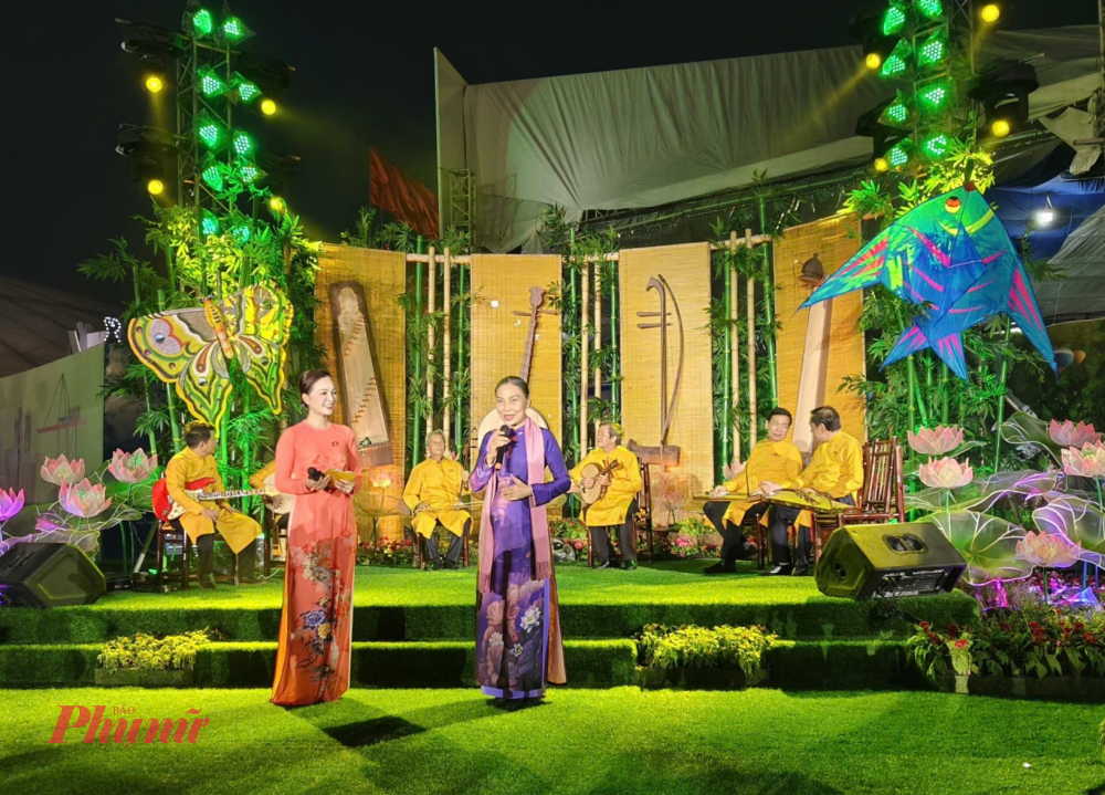 Tiến sĩ Mai Mỹ Duyên (phải) giới thiệu về nghệ thuật Đờn ca tài tử Nam bộ đến khán giả tham quan triển lãm - Ảnh: Thái Bình.