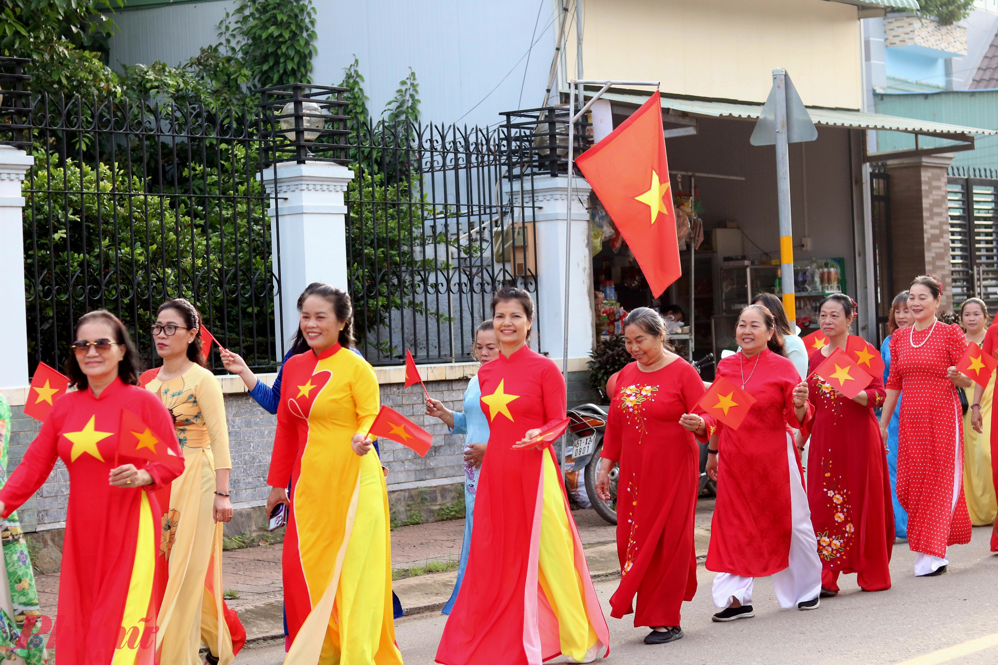 Các dì, các chị cùng vẫy cờ Tổ quốc khi diễu hành trên tuyến đường Trần Trọng Khiêm - Ảnh: Mẫn Nhi