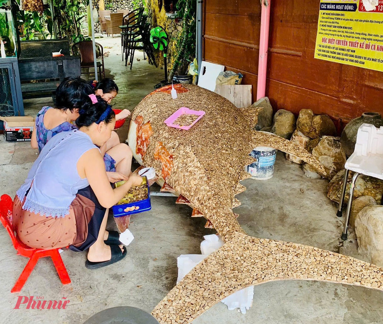 Công đoạn lắp, dán từng mảnh gáo dừa lên hình con cá.