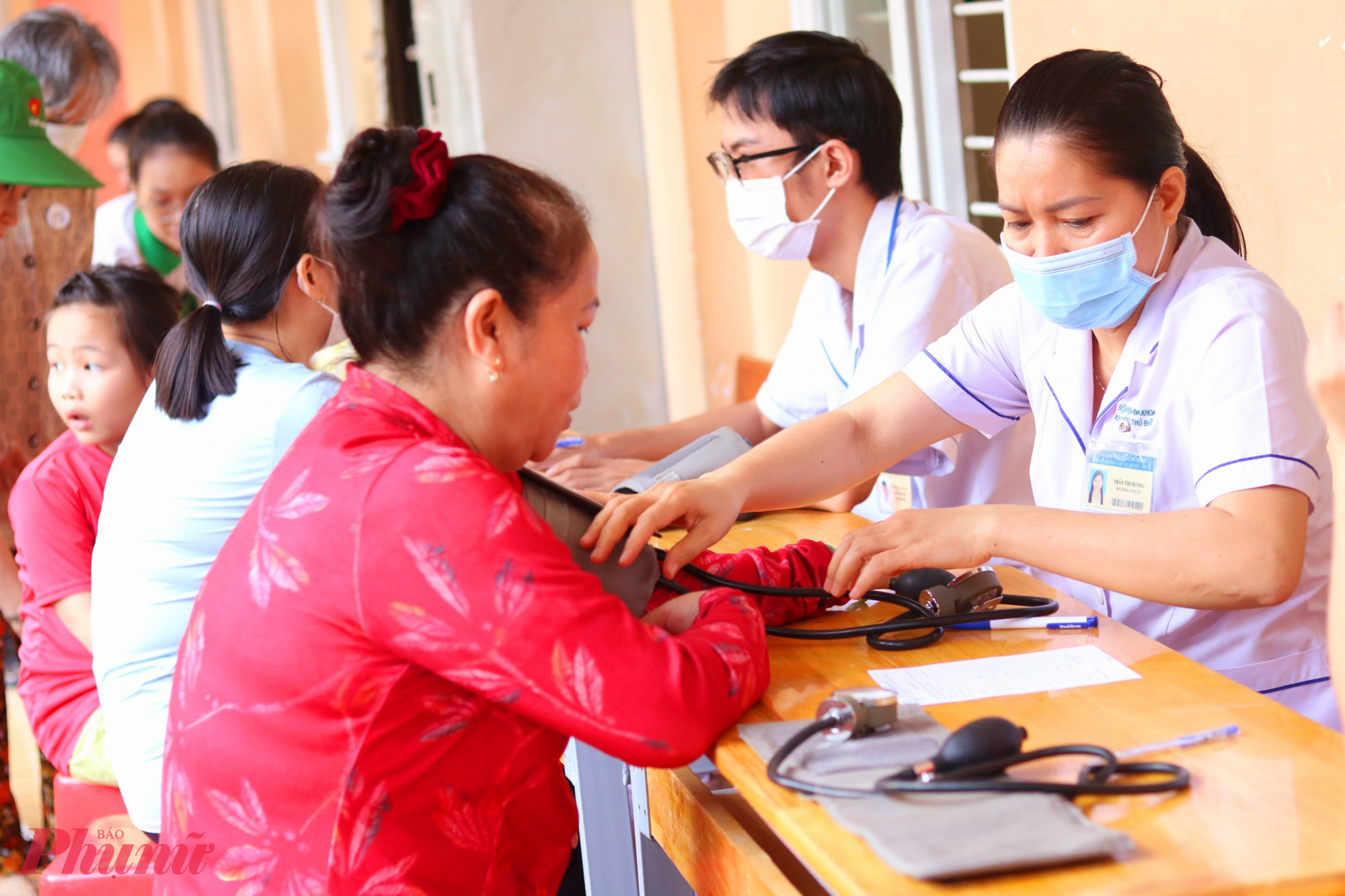 Người dân được kiểm tra huyết áp và khám bệnh, tư vấn chăm sóc sức khoẻ - Ảnh: Mẫn Nhi