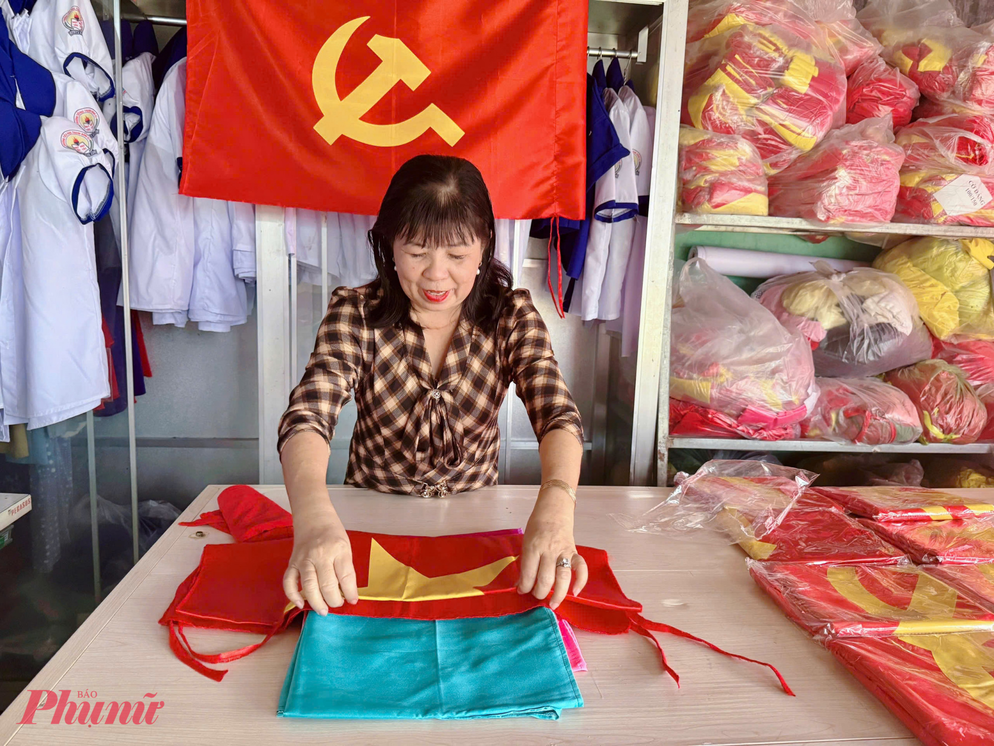 Chị Nguyễn Kiều Thu tỉ mĩ sắp xếp lại lá cờ đã hoàn thiện - Ảnh Phú Hữu