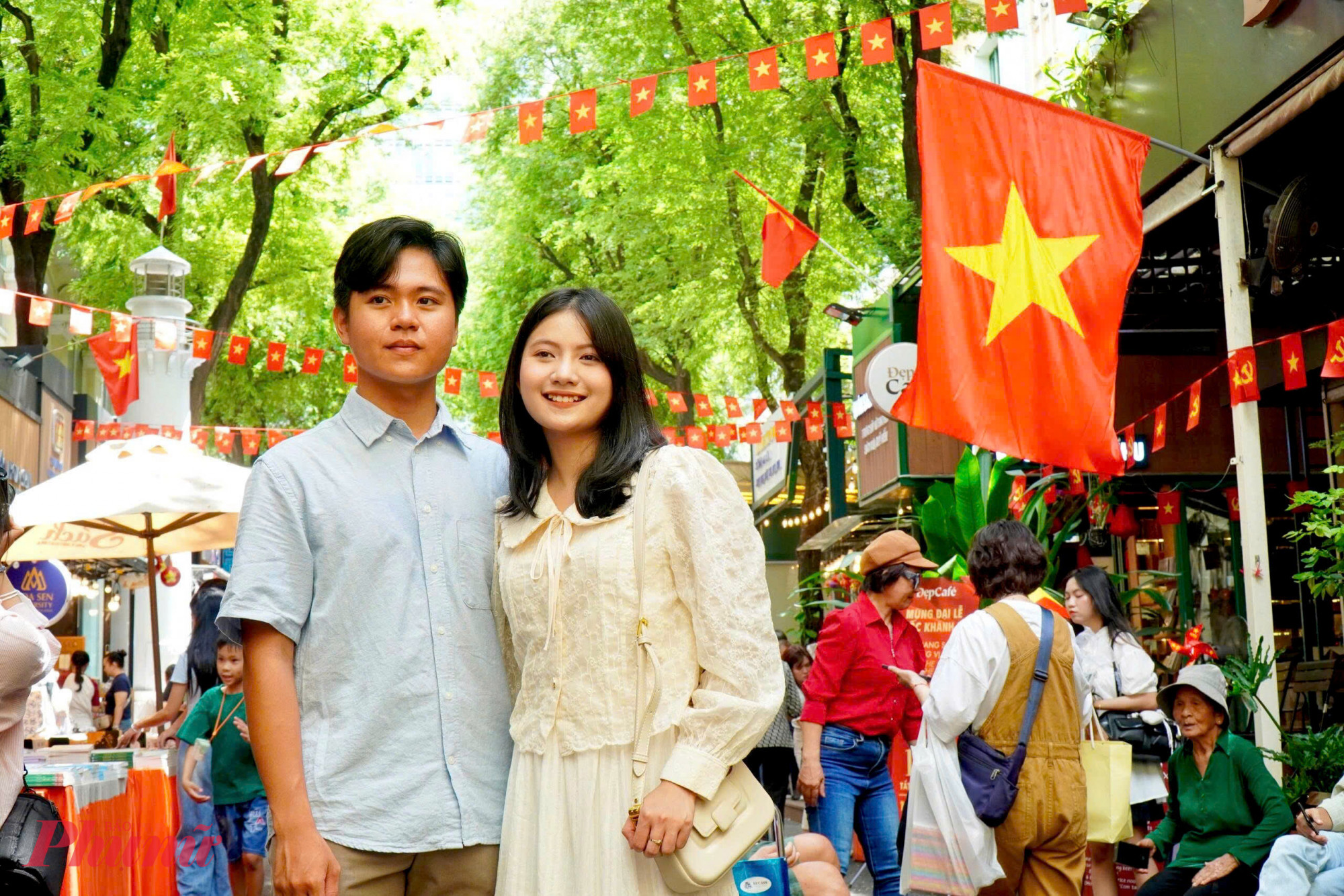 Một cặp đôi ghi lại khoảnh khắc kỷ niệm ở Đường sách trước dãy quốc kỳ. Bức ảnh không chỉ là kỷ niệm tình yêu đôi lứa, mà còn là kỷ niệm gắn liền với niềm tự hào dân tộc trong một ngày lễ trọng đại.