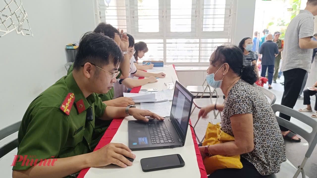 Cán bộ phường Tân Sơn Nhất tận tình hướng dẫn người dân làm thủ tục nhận quà - Ảnh: Thanh Tâm