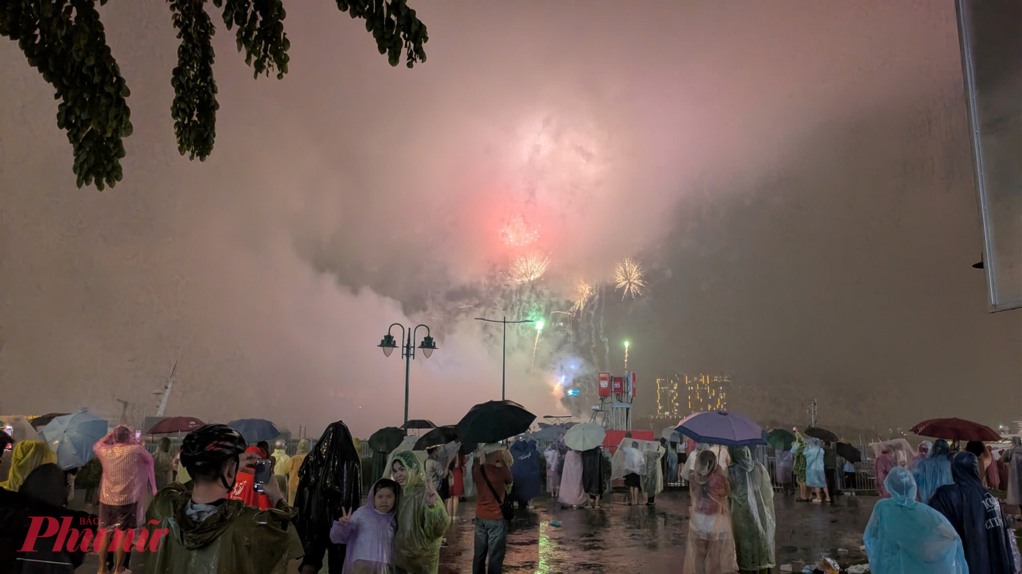 Người dân ngắm pháo hoa trong trời mưa nặng hạt