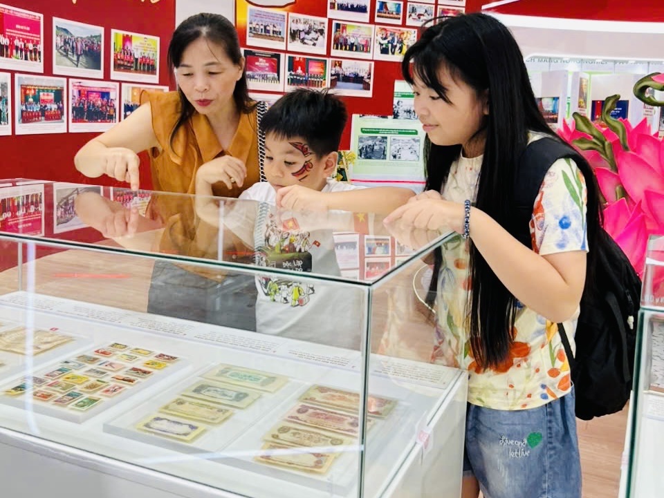 Đi dưới bóng cờ độc lập Người mẹ giảng giải cho con nghe ý nghĩa của những kỷ vật kháng chiến (nguồn: Bảo tàng Mặt trận Tổ quốc Việt Nam)