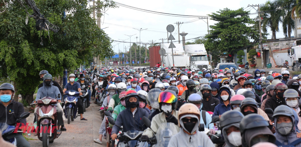 Nhiều xe máy chạy lên vỉa hè để thoát kẹt xe trên đường Nguyễn Thị Định hướng về trung tâm TPHCM.