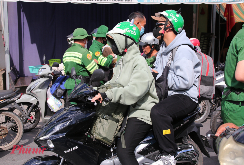 Nhiều người dân lỉnh kỉnh đồ đạc trên xe máy trở lại TPHCM và khá mệt mỏi khi chờ đợi lâu vì kẹt xe.