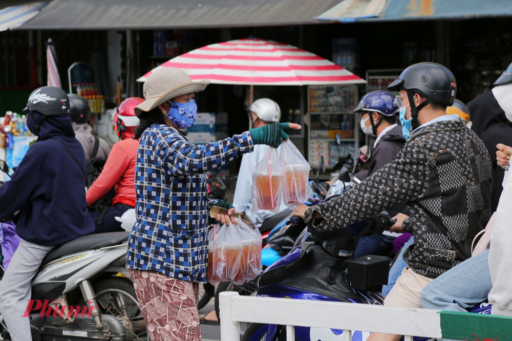 Tranh thủ kẹt xe, một số người bán hàng mang nước mía mời chào người dân mua. 