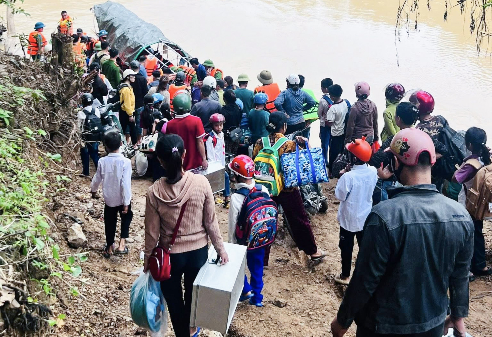 Hàng trăm học sinh tập trung ở 2 bên bờ sông chờ được chở sang sông để đến trường - Ảnh: Văn Hòa