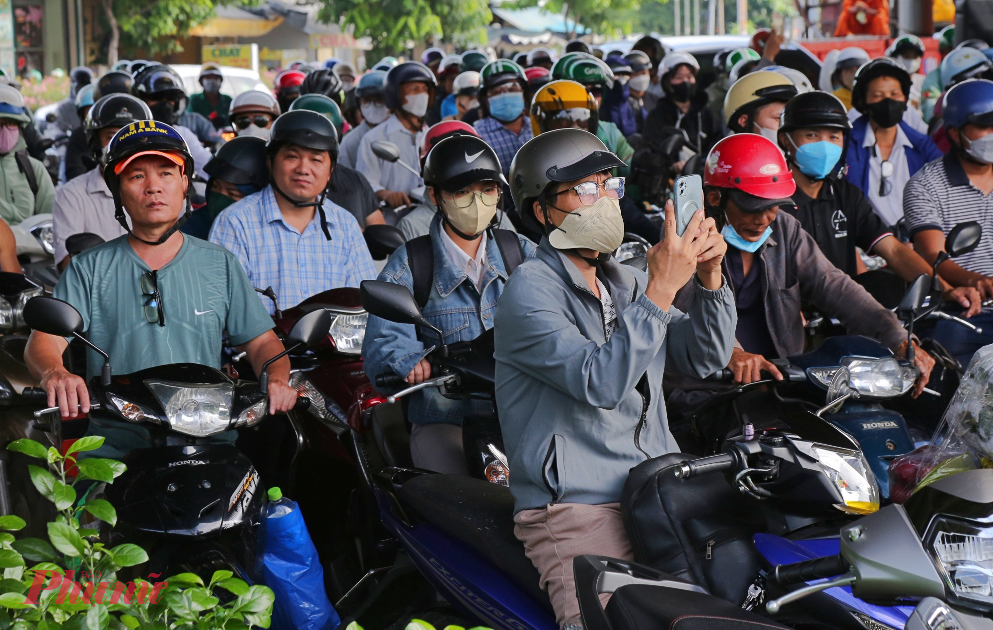 Một số người tranh thù dùng điện thoại quay lại cảnh kẹt xe trong ngày đầu đi làm sau nghỉ lễ Quốc khánh trong lúc chờ đợi.