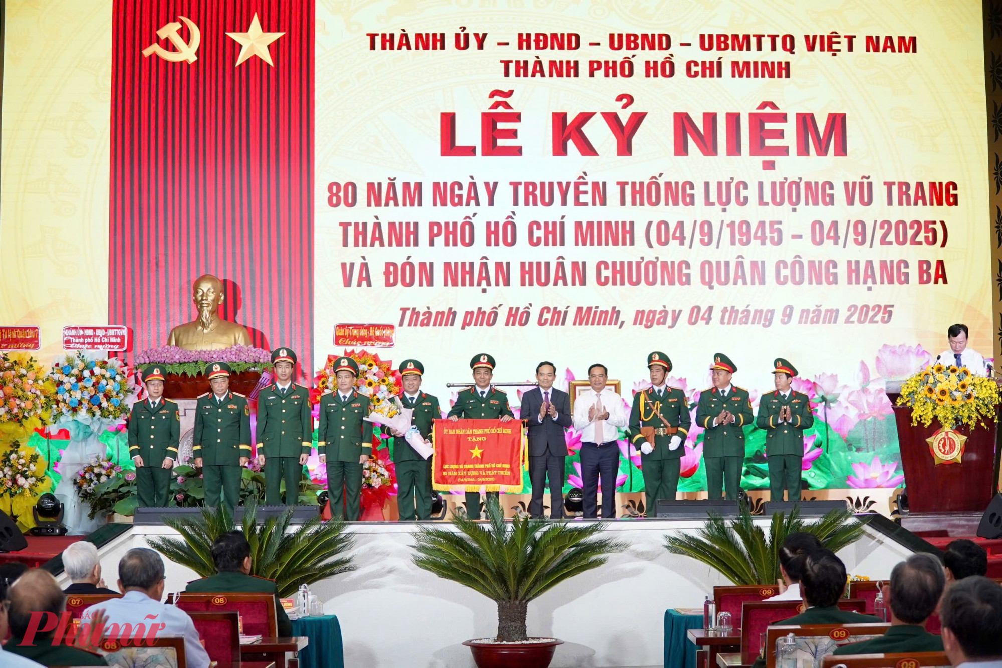 Bí thư Thành ủy TPHCM Trần Lưu Quang và Chủ tịch UBND TPHCM Nguyễn Văn Được trao Cờ truyền thống cho Lực lượng vũ trang TPHCM - Ảnh: Thanh Tâm