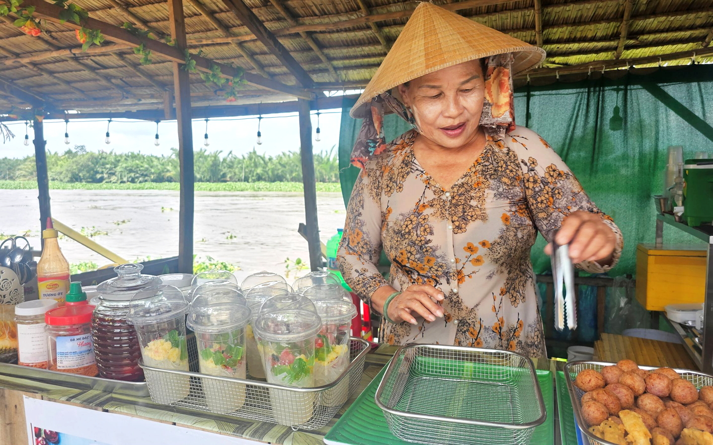 Bà Nguyễn Ngọc Thơ sắp xếp gian hàng chuẩn bị phục vụ khách tham quan