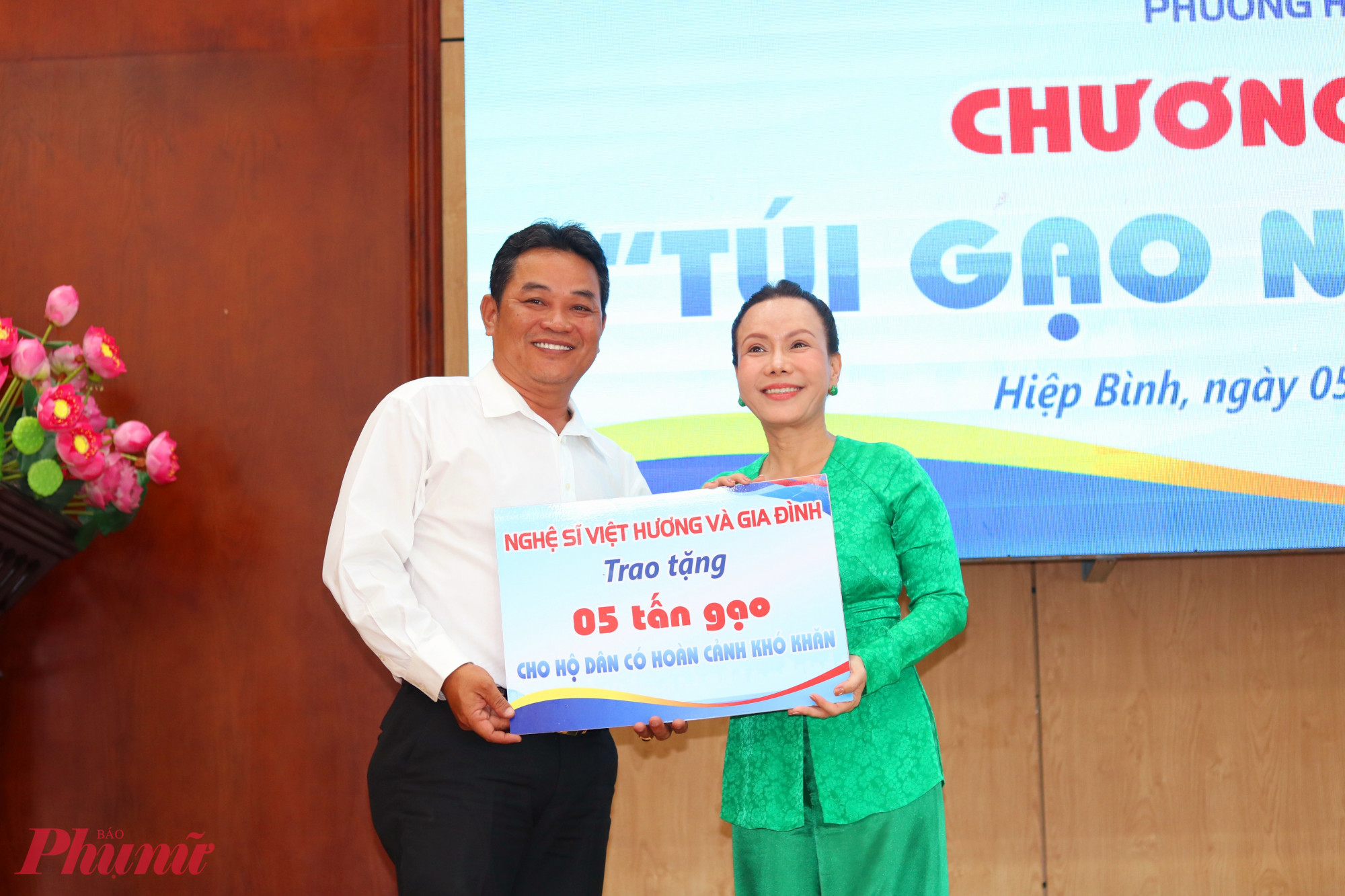 Ông Phan Hồng Điệp - Chủ tịch Ủy ban MTTQ Việt Nam phường Hiệp Bình - nhận bảng tượng trưng tặng 5 tấn gạo cho chương trình “Túi gạo nghĩa tình” từ nghệ sĩ Việt Hương - Ảnh: Mẫn Nhi