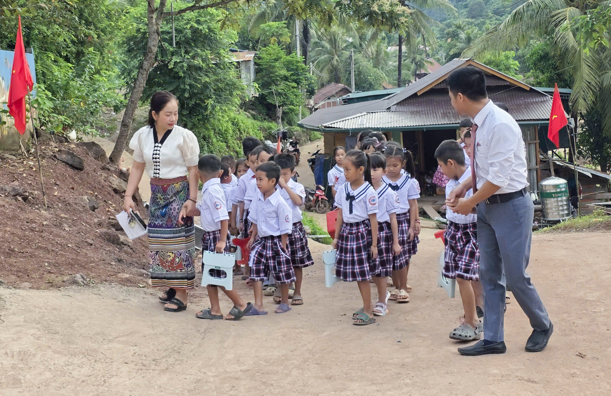 Các em học sinh Trường Phổ thông Dân tộc bán trú tiểu học Mỹ Lý 2 phải đi khải giảng nhờ vì trường bị lũ tàn phá - Ảnh: Khánh Trung