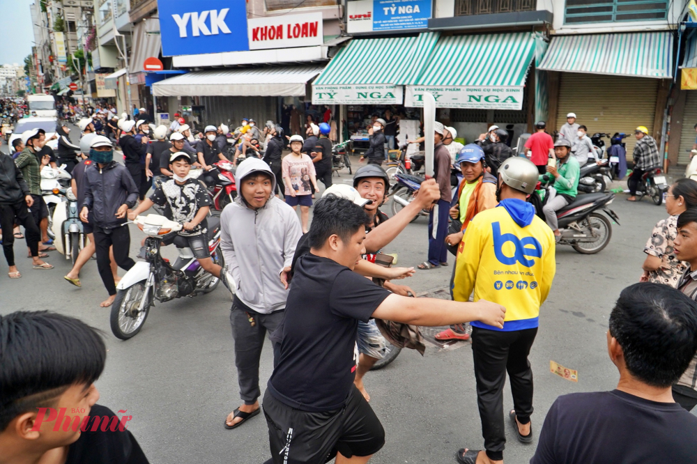 Thanh niên này tiếp tục cầm hung khí giơ lên cao và vung loạn xa để thị uy sức mạnh, hòng khiến đối phương không tranh giành giật tiền cô hồn. 