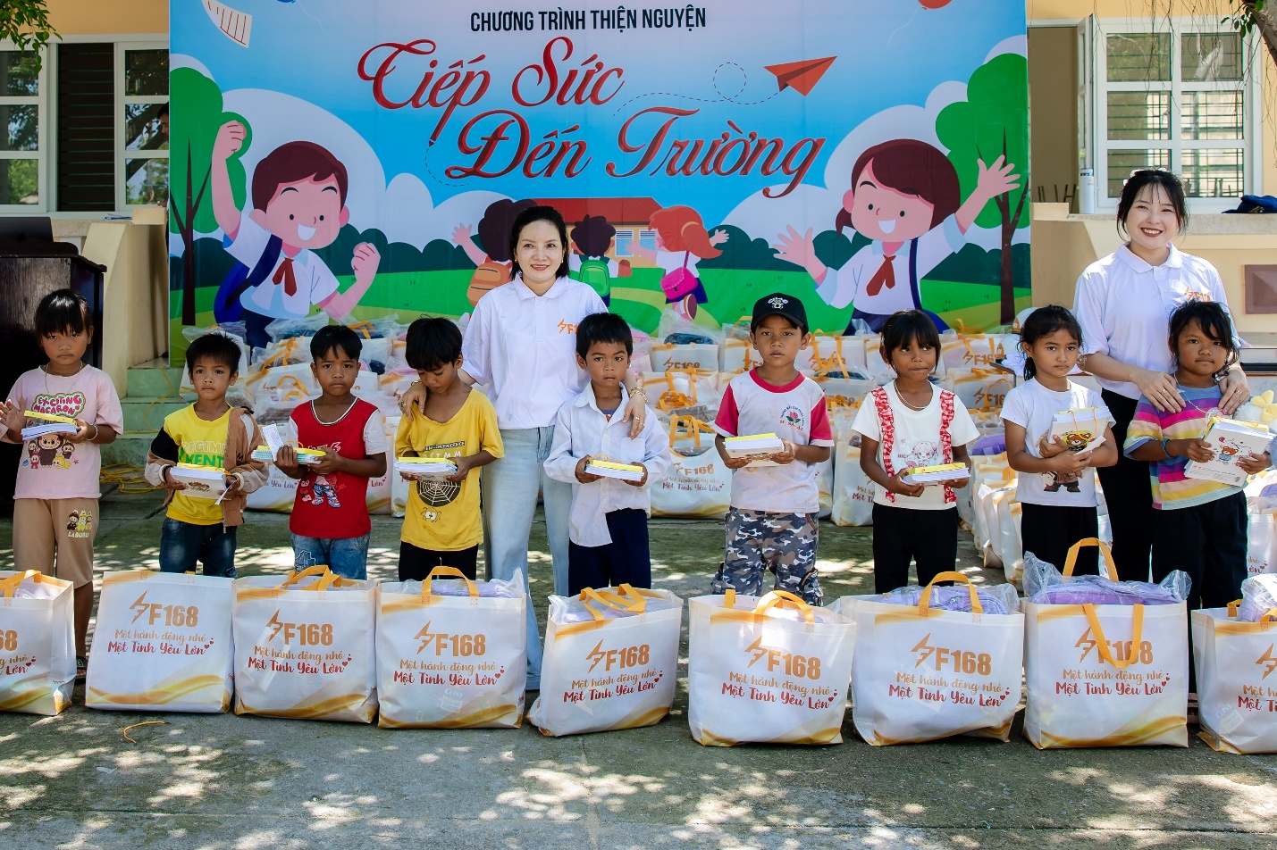 Đại diện của Công ty TNHH Truyền thông và Giải trí F168 trao quà cho các em - Ảnh: F168