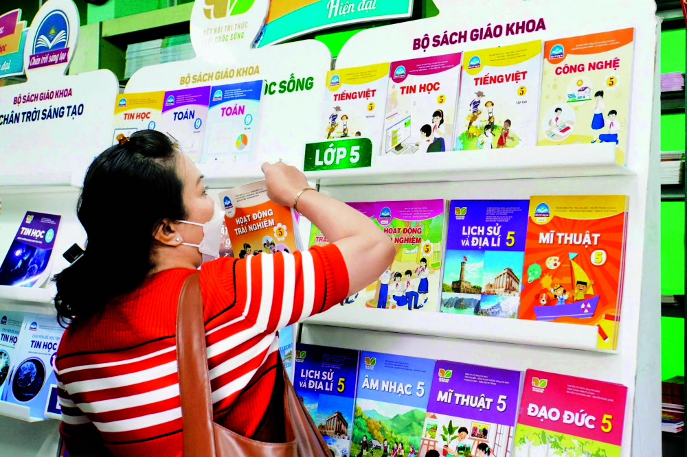 Phụ huynh đang chọn mua sách giáo khoa tại một siêu thị ở TPHCM trước thềm năm học mới ẢNH: NGUYỄN LOAN