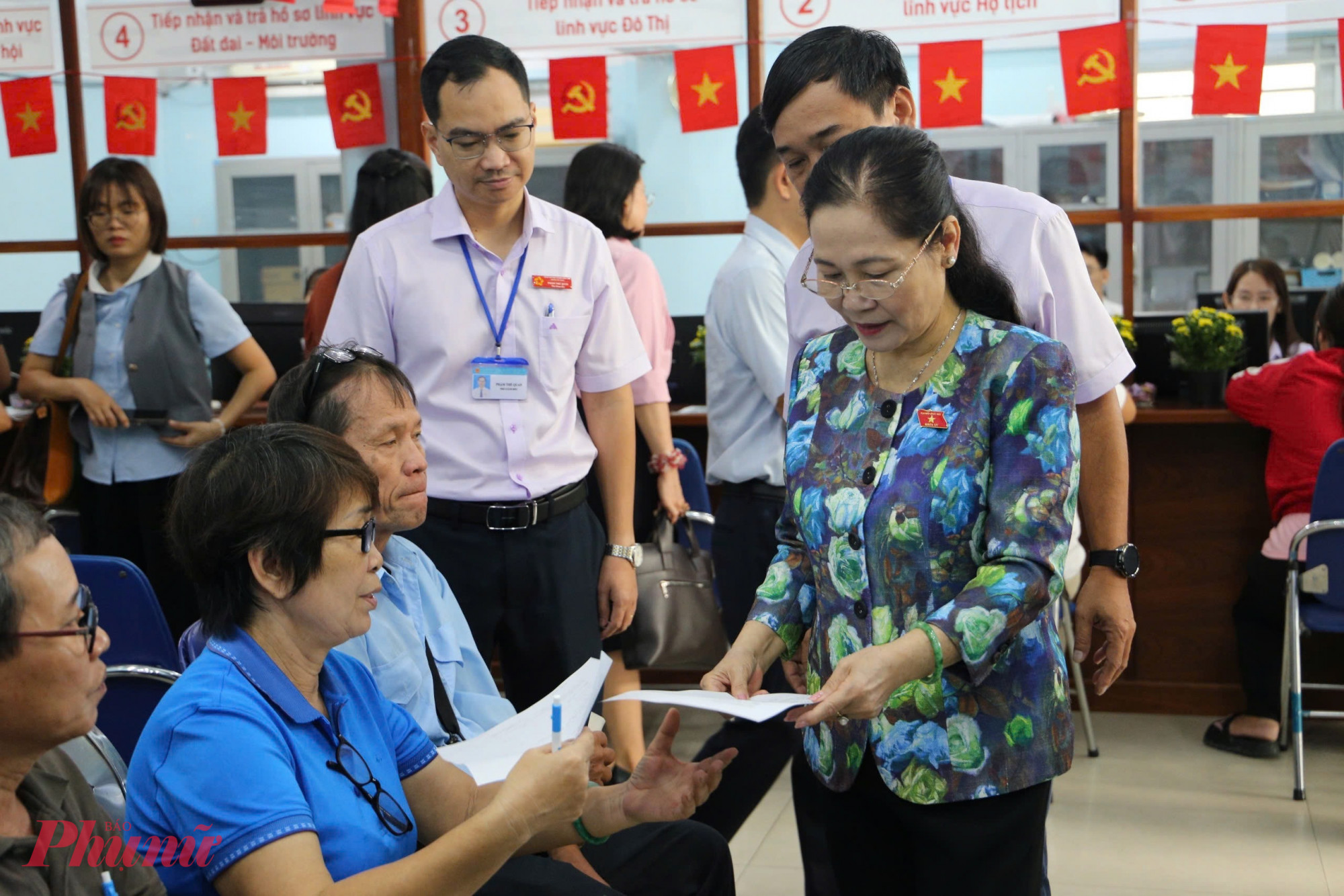 Bà Nguyễn Thị Lệ - nguyên Chủ tịch HĐND TPHCM - trao đổi cùng người dân thực hiện thủ tục hành chính tại phường Phú Thuận - Ảnh: Thanh Tâm