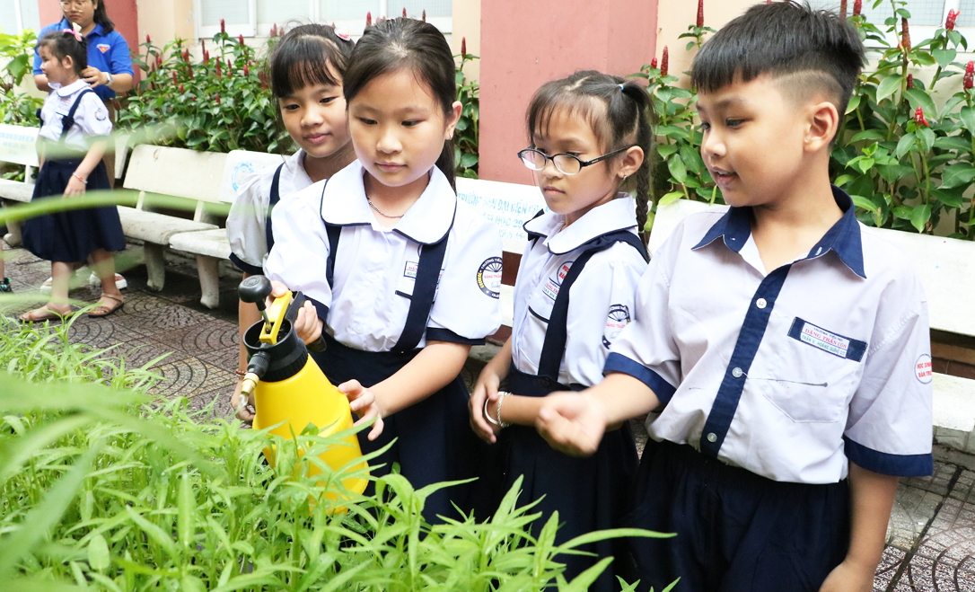 Học sinh Trường tiểu học Đặng Trần Côn chăm sóc vườn cây trước giờ vào lớp
