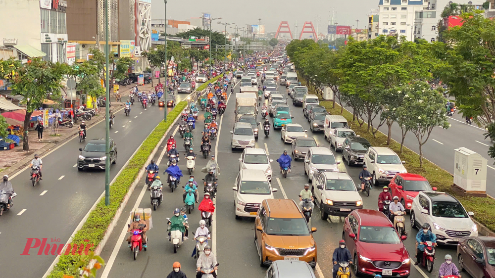 Ô tô nối đuôi nhau từ trên cầu Bình Lợi xuống đường Phạm Văn Đồng. 