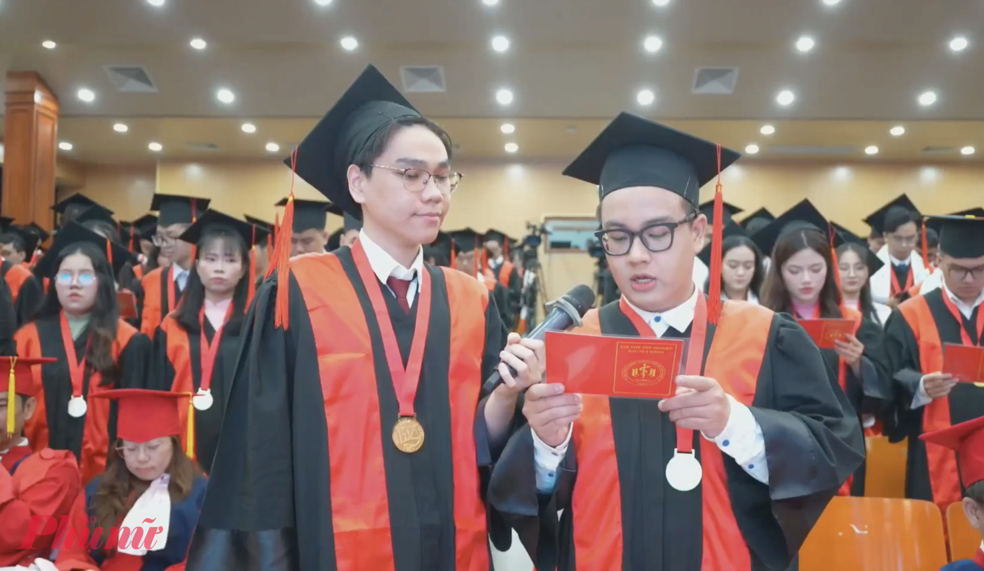 Thủ khoa đầu ra Dương Nhật Nam (bên trái) và tân bác sĩ Phạm Duy Tân - Khối trưởng khối Y khađọc và cam kết thực hiện lời thề y khoa - Ảnh: N.L