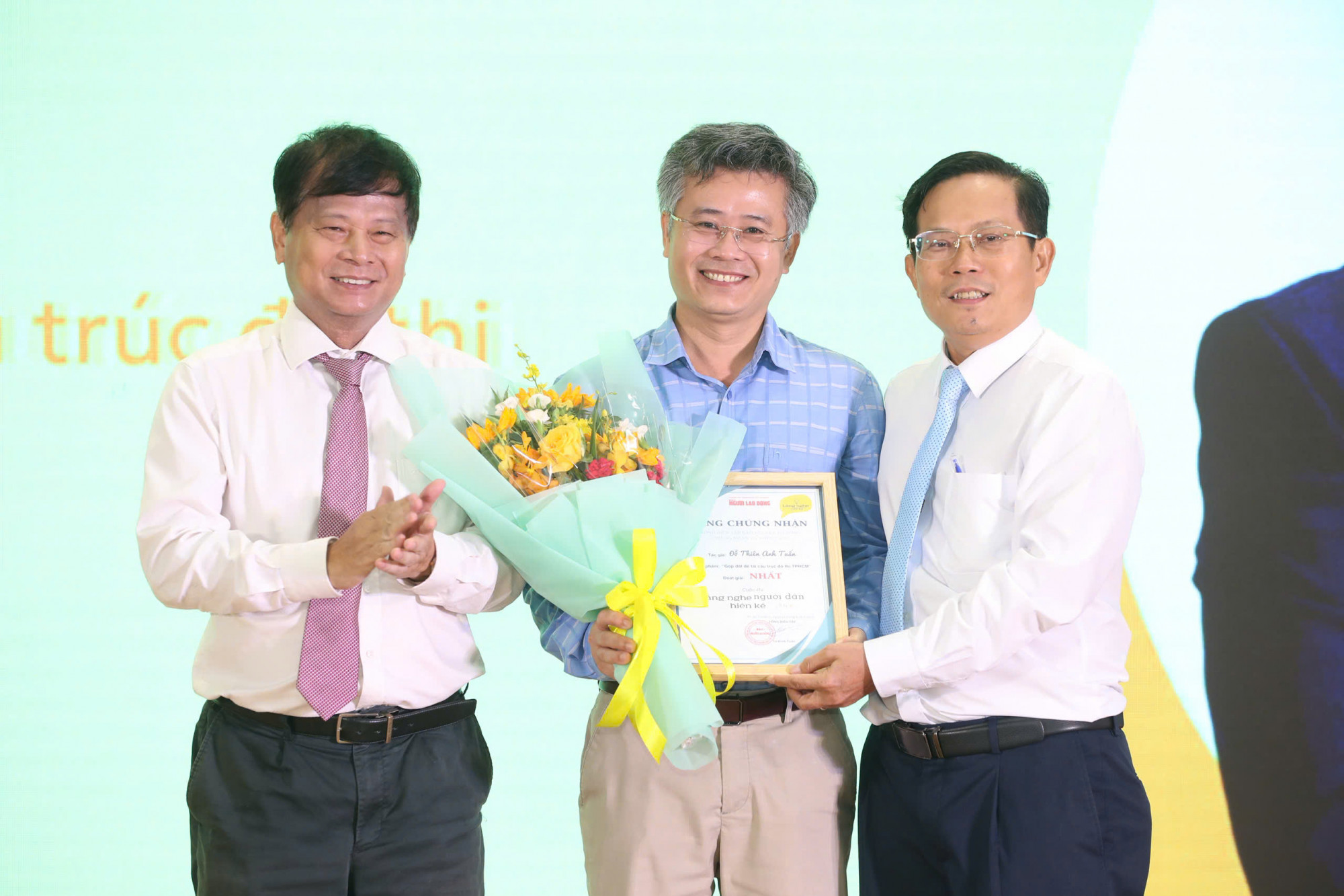 Ông Trần Trọng Dũng - Phó chủ tịch Hội Nhà báo Việt Nam và ông Tô Đình Tuân - Tổng biên tập báo Người Lao Động - trao giải nhất cho tác giả Đỗ Thiên Anh Tuấn 