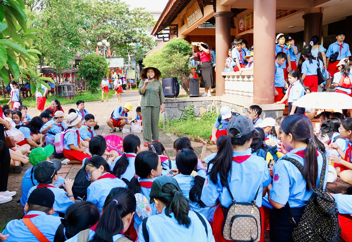 O Kình đang giới thiệu về cầu ngói Thanh Toàn với học sinh