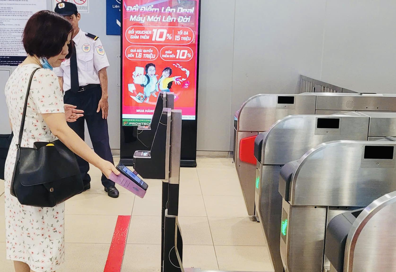 Hành khách mua vé bằng ứng dụng khi đi tàu metro - Ảnh: HURC1