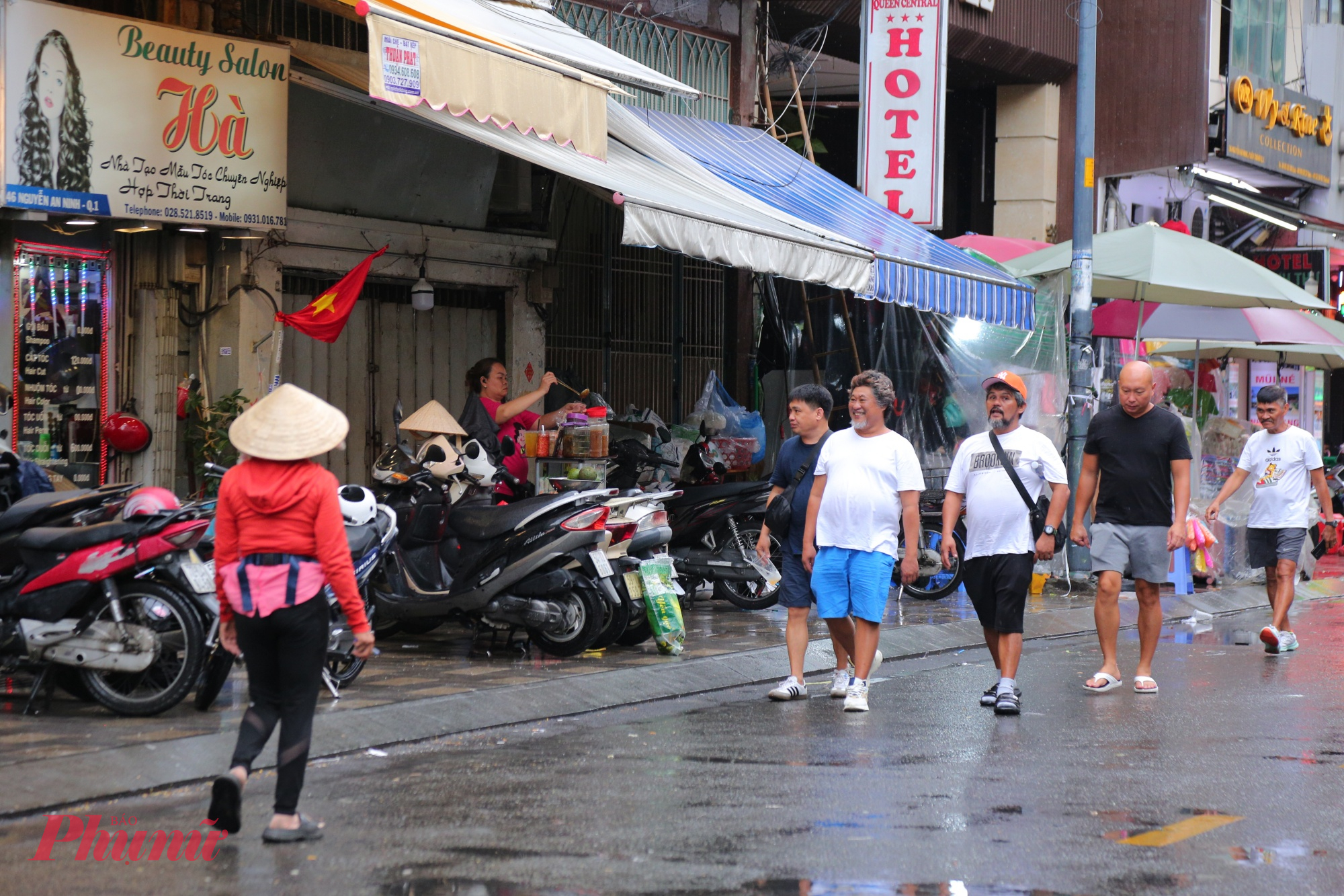 Du khách đi bộ phải tràn xuống lòng đường vì vỉa hè trên đường Nguyễn An Ninh bị chiếm dụng.