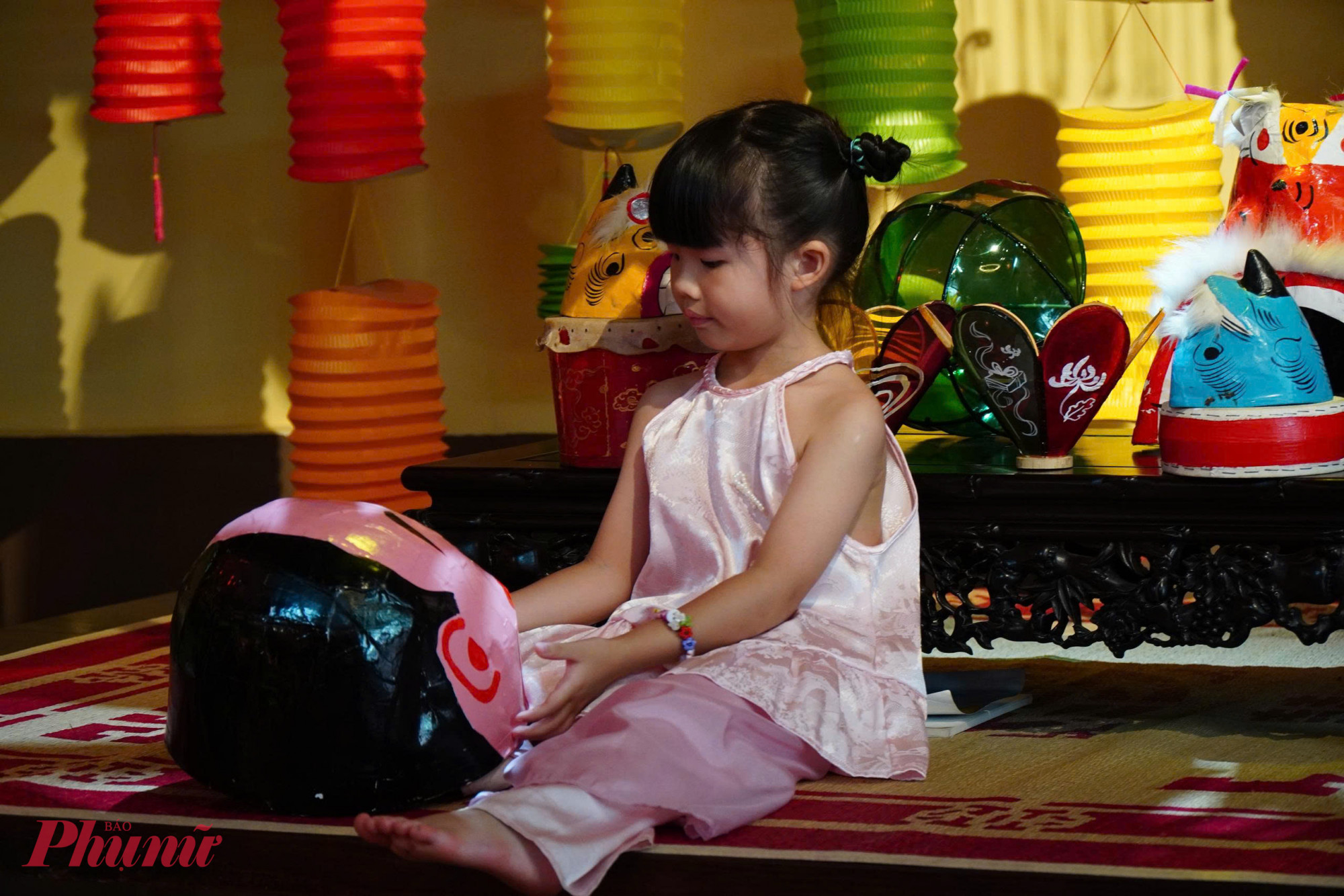Bé nhỏ háo hức lưu giữ khoảnh khắc bên lồng đèn cổ, tìm thấy chút hồn Trung thu xưa trong nhịp sống hiện đại. Trong không gian rộng khoảng 80 m², hơn 50 mẫu lồng đèn được trưng bày: từ hình dáng thân quen như cá chép, cua, bươm bướm… 