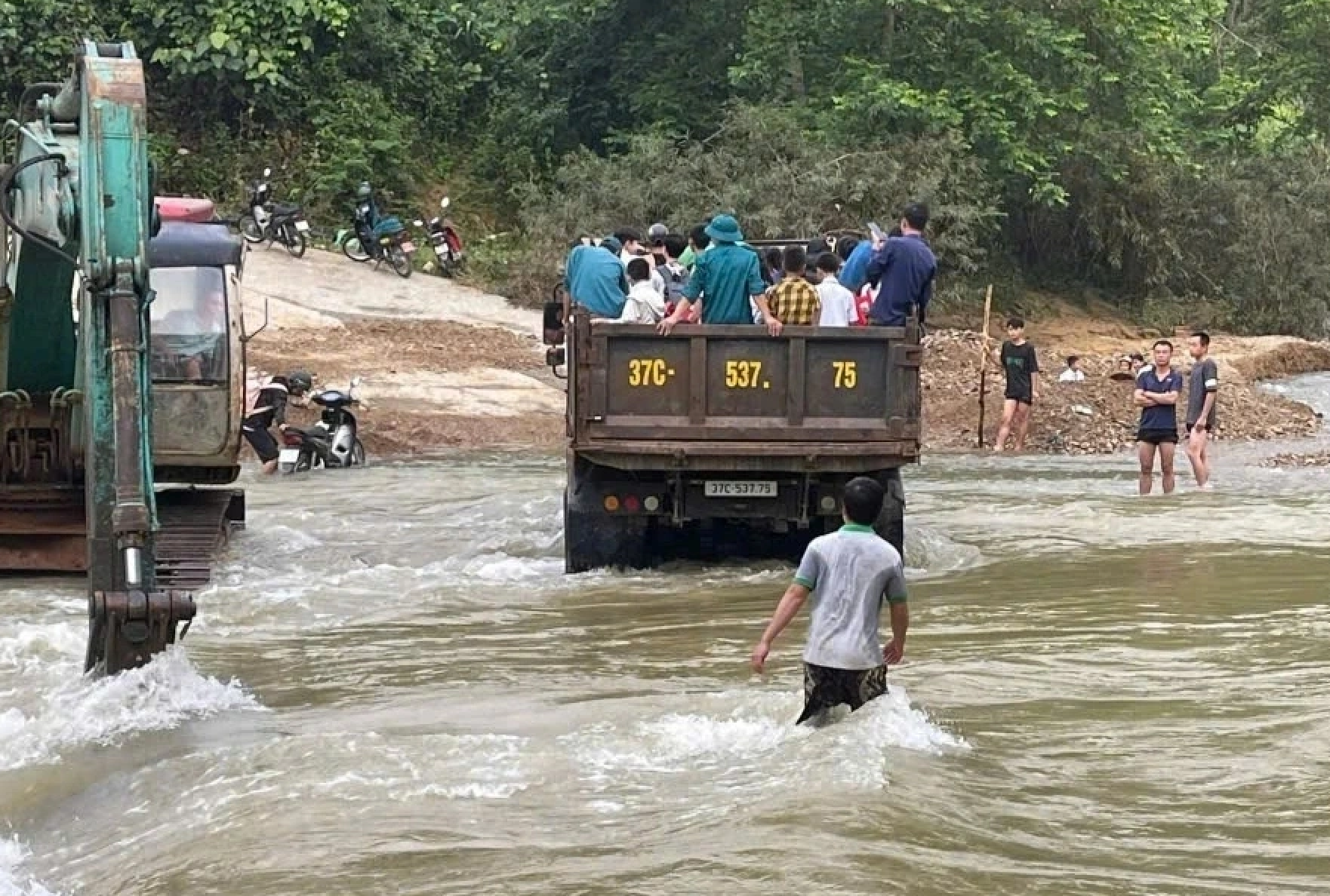 Lực lượng chức năng xã Yên Hòa dùng xe tải chở học sinh vượt qua đoạn đường ngập đến trường - Ảnh: Đài Trang