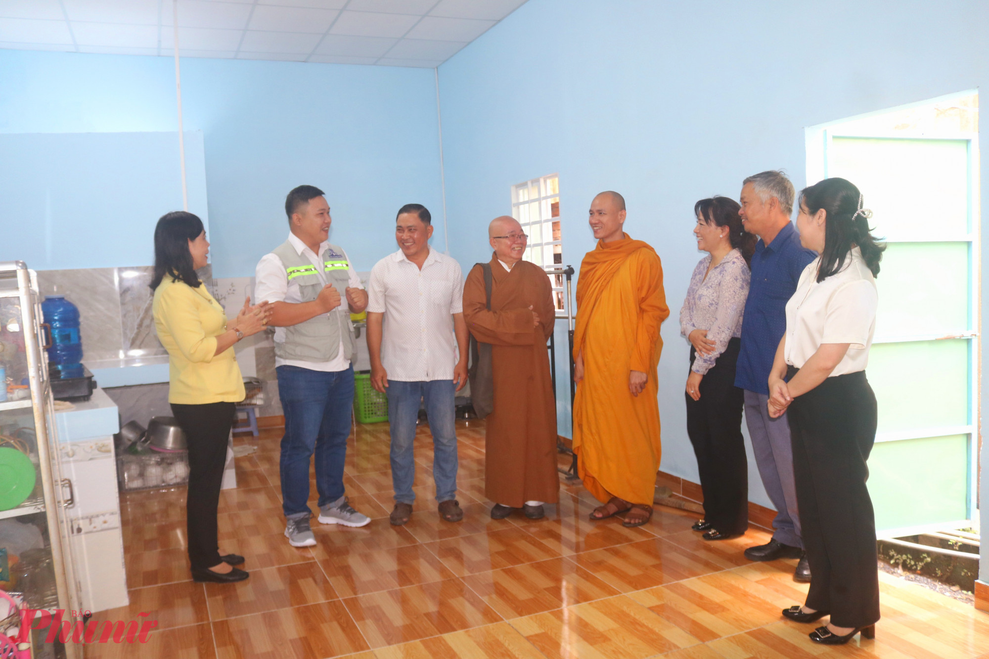 Đại biểu tham quan, chúc mừng cha con anh Út (thứ 3, từ trái qua) có căn nhà khang trang, không còn lo dột, ngập - Ảnh: Mẫn Nhi