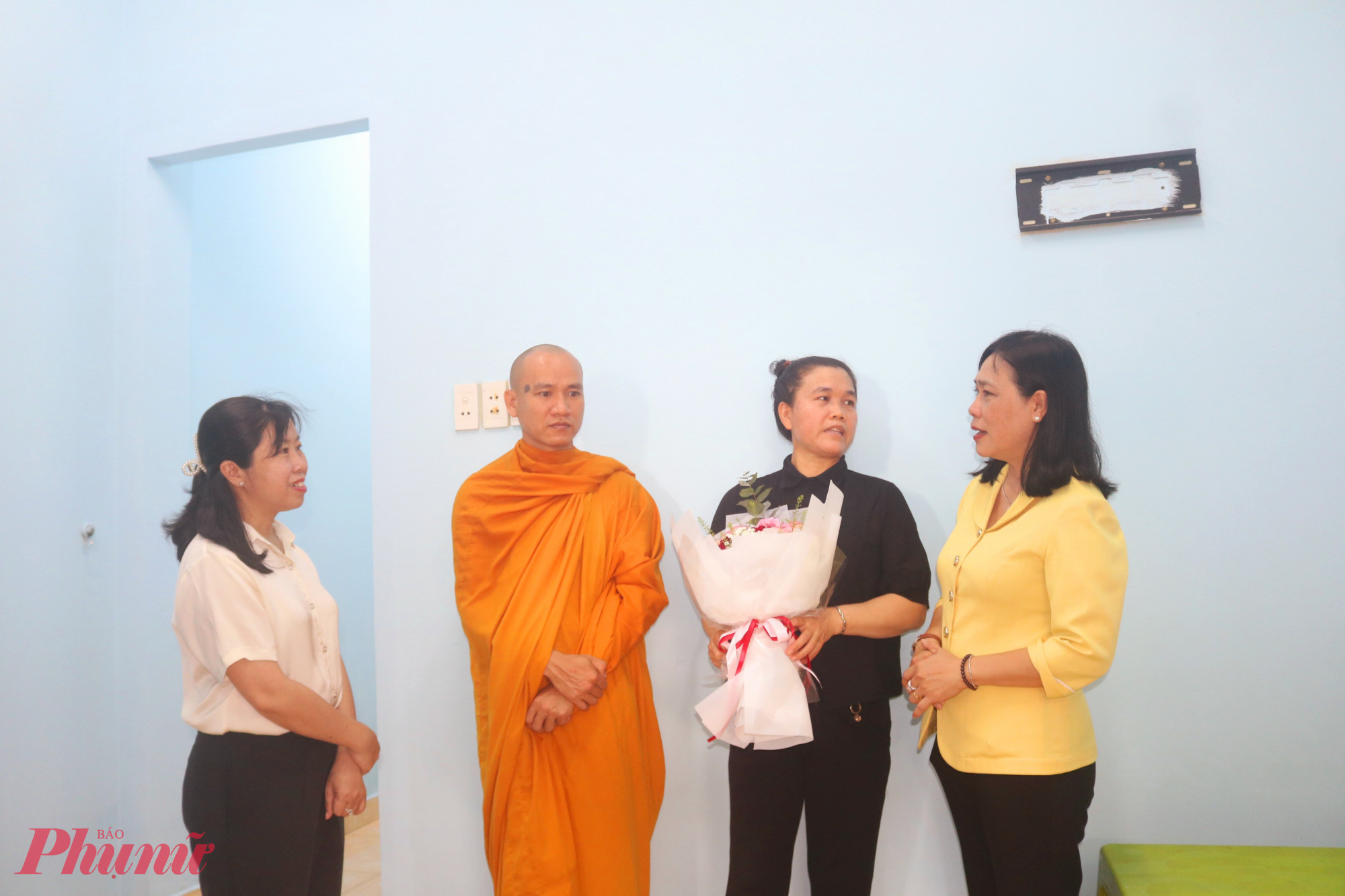 Nhận bàn giao nhà, chị Hạnh (thứ 2, từ phải qua) rất xúc động. Chị nói nếu không được địa phương giúp, có lẽ mẹ con chị sẽ mãi sống trong cảnh nhà hễ mưa là dột và ngập lênh láng, còn ngày nắng thì nóng ngộp - Ảnh: Mẫn Nhi 