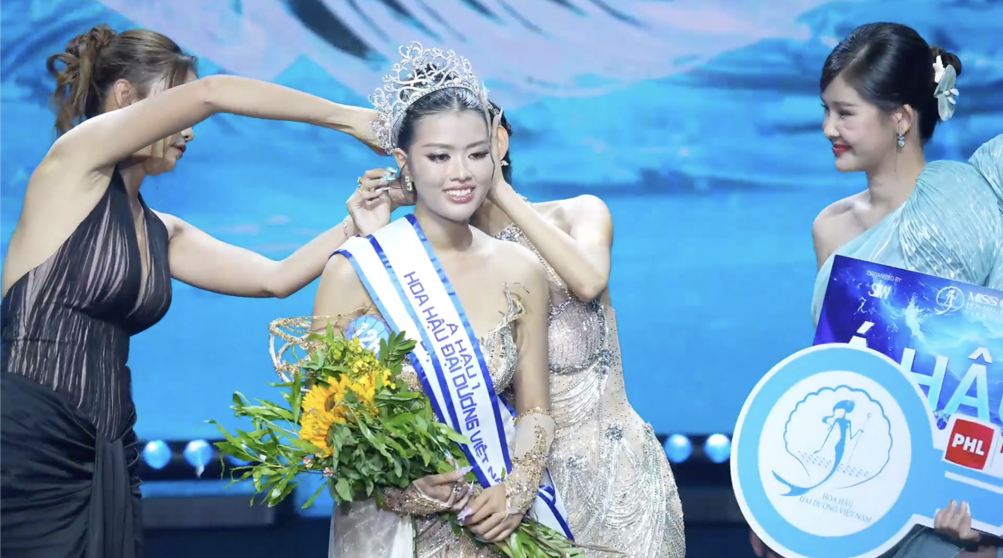 Vương miện quá rộng nên các hoa hậu phải giúp sức để cố định cho Phương Vi trong lúc nhận danh hiệu á hậu 1