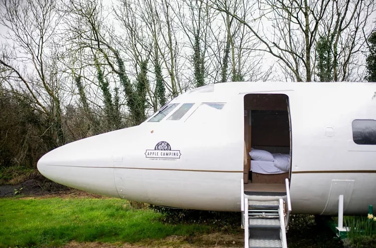 Khu cấm trại sang trọng Apple Camping ở Pembrokeshire, xứ Wales tái sử dụng container, toa xe lửa làm phòng nghỉ cho khách. Điểm nổi bật và cũng được khách yêu thích nhất khi đến đây là nghỉ trong chiếc máy bay phản lực tư nhân. Nó được mang về từ bãi phế liệu máy bay và chủ nhân đầu tiên là tỷ phú Howard Hughes - Ảnh: Bên ngoài nhà nghỉ máy bay.