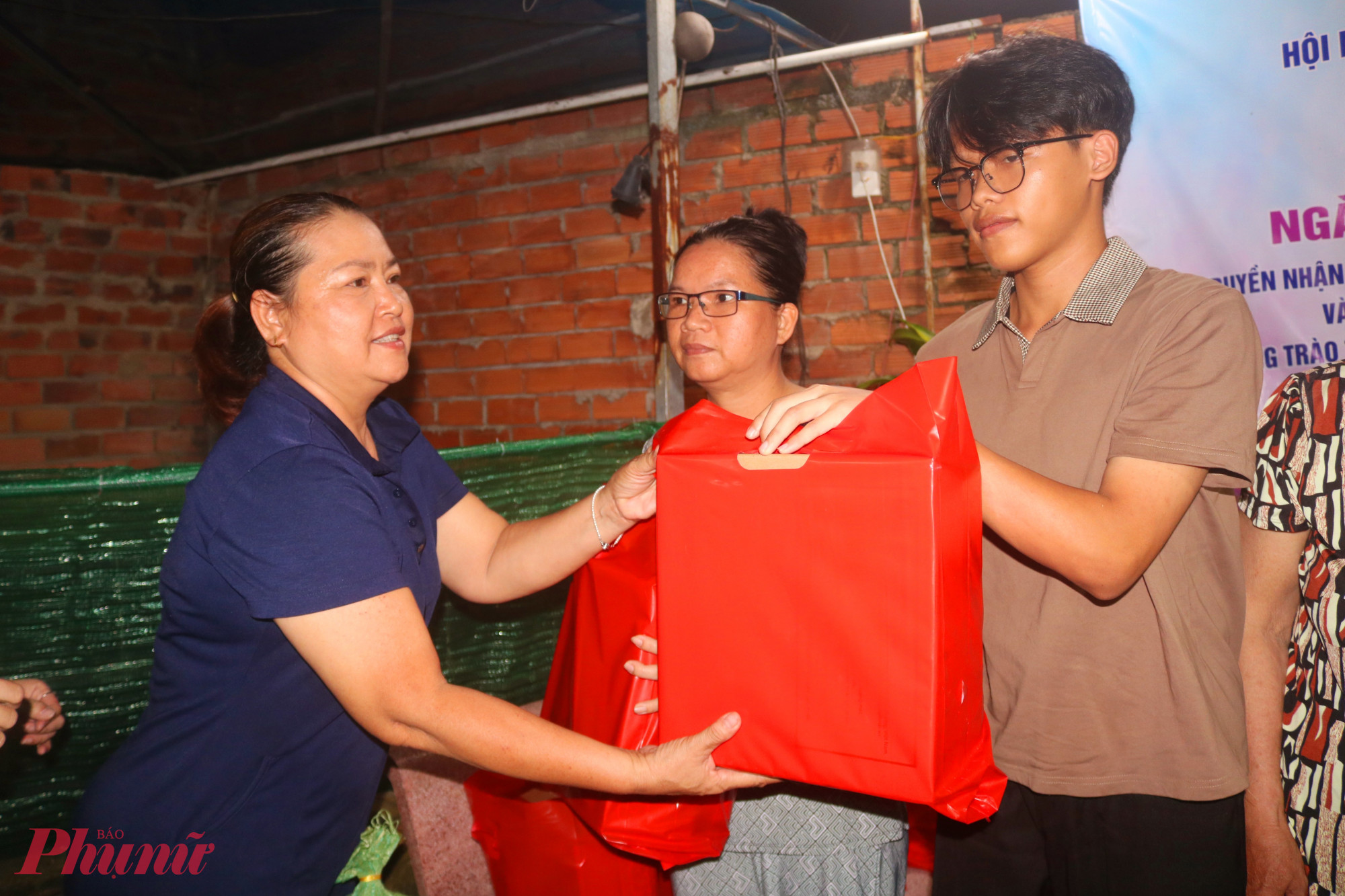 Chủ khu nhà trọ - chị Trương Đài Giang Thi – trao những phần quà nghĩa tình đến người lao động - Ảnh: Mẫn Nhi