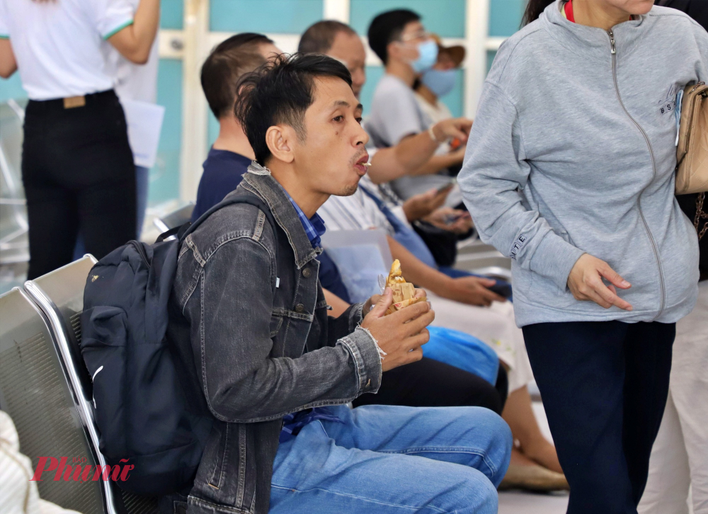 Một số hành khách tranh thủ ăn sáng trong lúc chờ mua vé trực tiếp tại quầy 