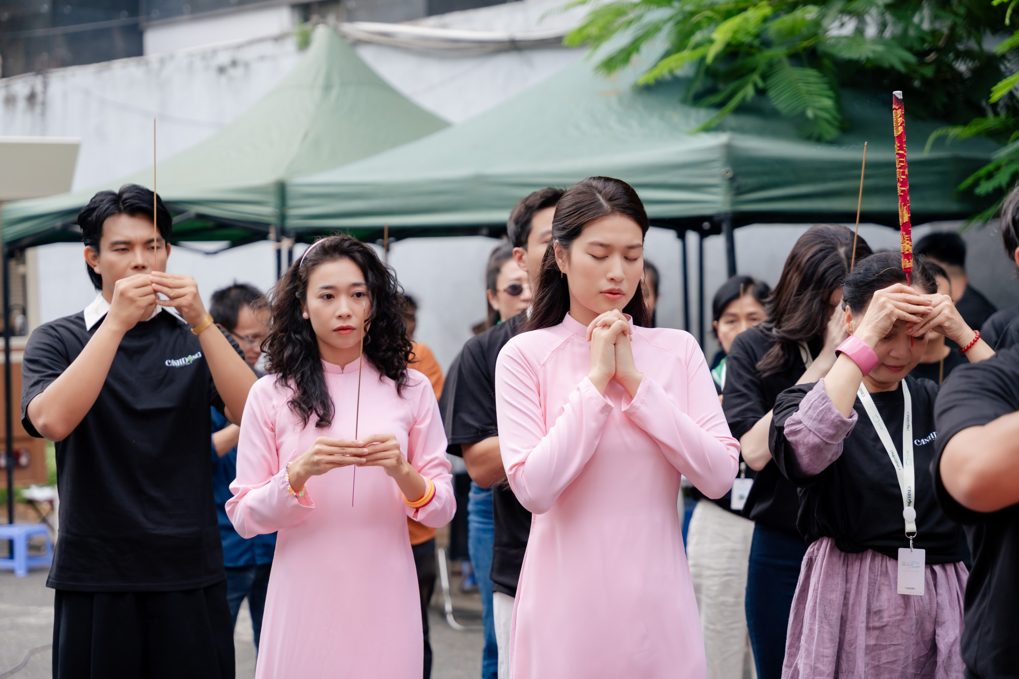 Trong phần nghi thức cúng khai máy, cô diện áo dài hồng pastel, khoe vẻ đẹp dịu dàng, trong sáng. Kiểu tóc xõa thẳng tự nhiên càng làm tôn lên gương mặt thanh tú và thần thái nền nã, toát lên sự thuần khiết đúng chất “nàng thơ”.