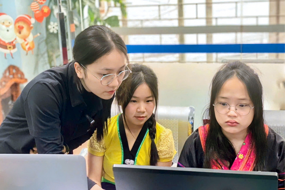 Lầu Nguyễn Hương Giang (bìa trái) hướng dẫn các tân sinh viên cách sử dụng laptop vừa được tặng