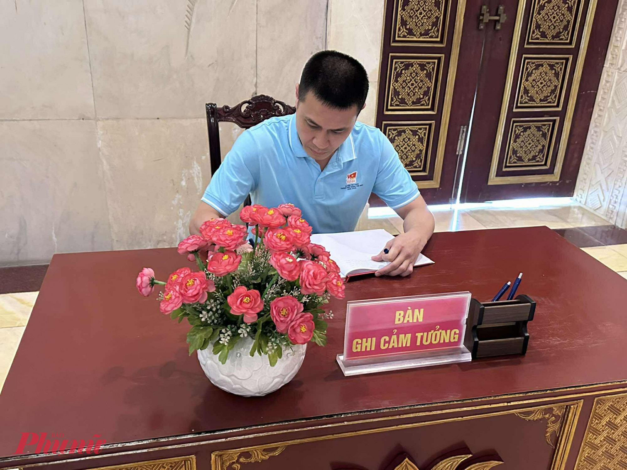 -Đồng chí Nguyễn Việt Long, Phó trưởng Ban Tuyên giáo và Dân vận Thành ủy TPHCM viết sổ lưu niện tại Nhà