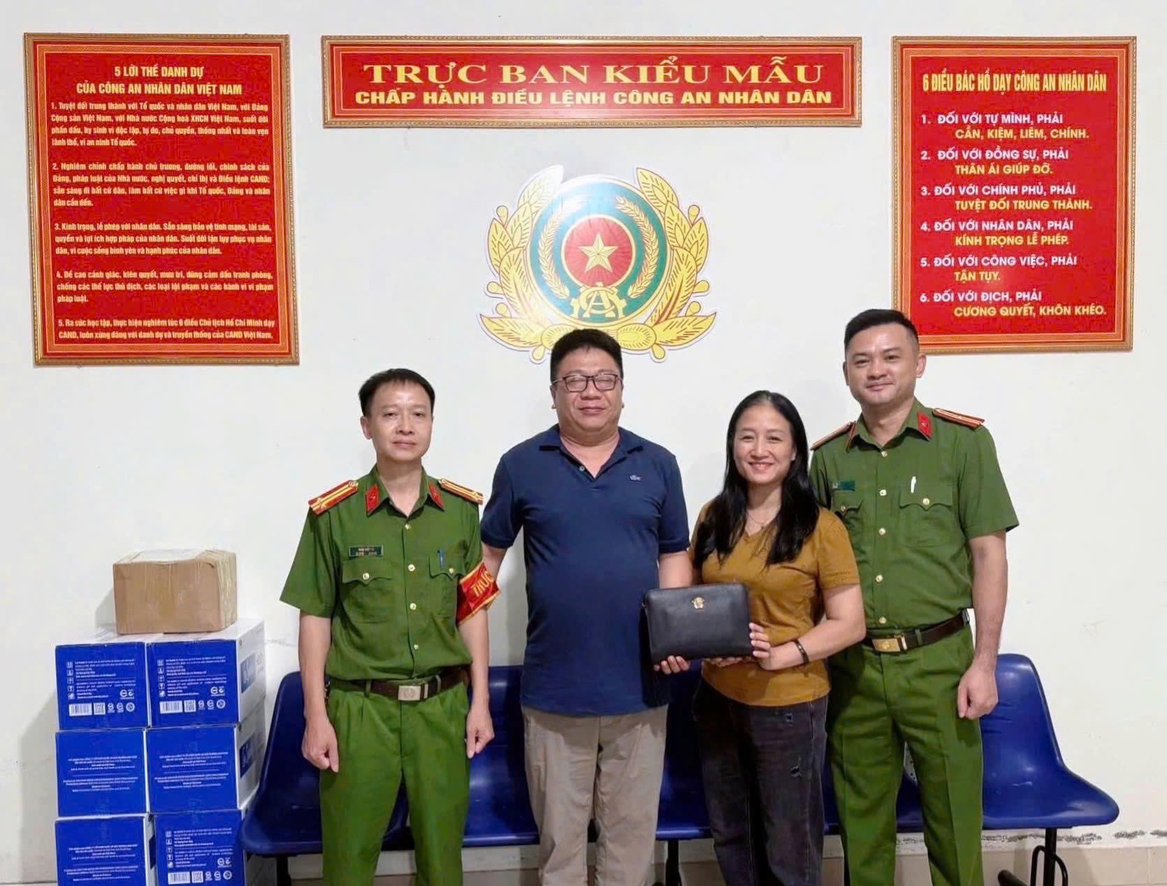 Chị Tú cùng cơ quan công an trao trả lại tài sản cho người đánh rơi - Ảnh: Phan Tuyết