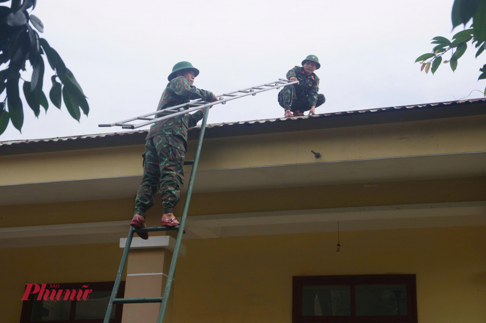 Cán bộ, chiến sĩ Tiểu đoàn hỗn hợp, Ban chỉ huy Phòng thủ khu vực 3 - Vĩnh Linh giúp đỡ trường học, người dân trên đặc khu Cồn Cỏ di chuyển vật chất, đồ dùng dạy học, chằng chống nhà cửa phòng, tránh bão.