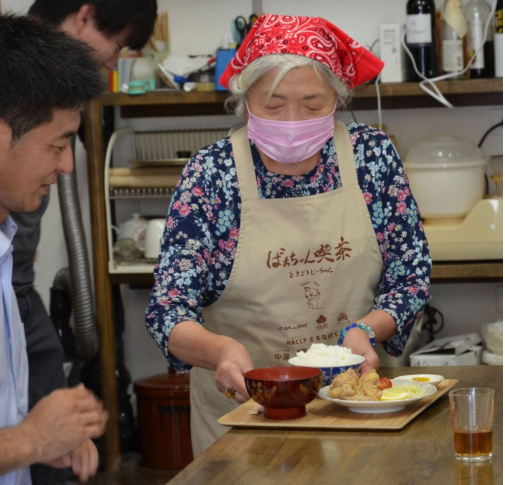 Nobuko Ishibashi phục vụ bữa trưa gà rán tại Grandma's Cafe vào tháng 8. Cô ấy rất khéo léo trong việc thái bắp cải. | Nishinippon Shimbun