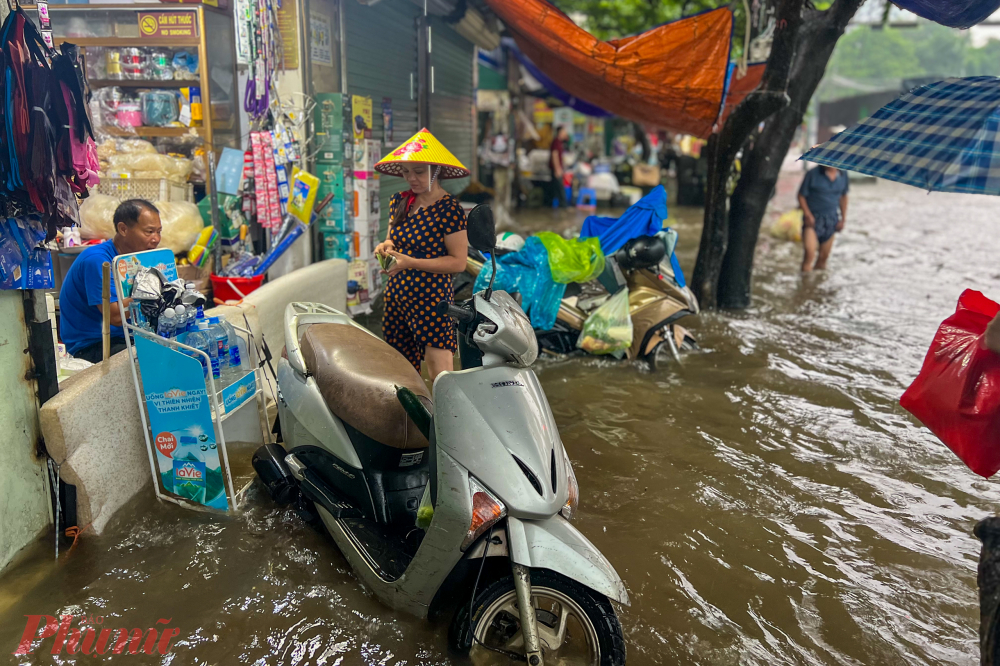 Các cửa hàng ở mặt đường phải dùng mọi cách để che chắn ngăn nước tràn sâu vào trong nhà.