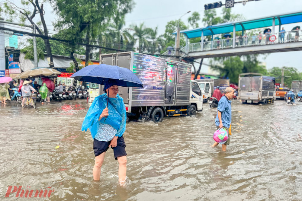 Người nhà bệnh nhân phải lội qua những đoạn nước ngập sâu khi muốn sang đường.