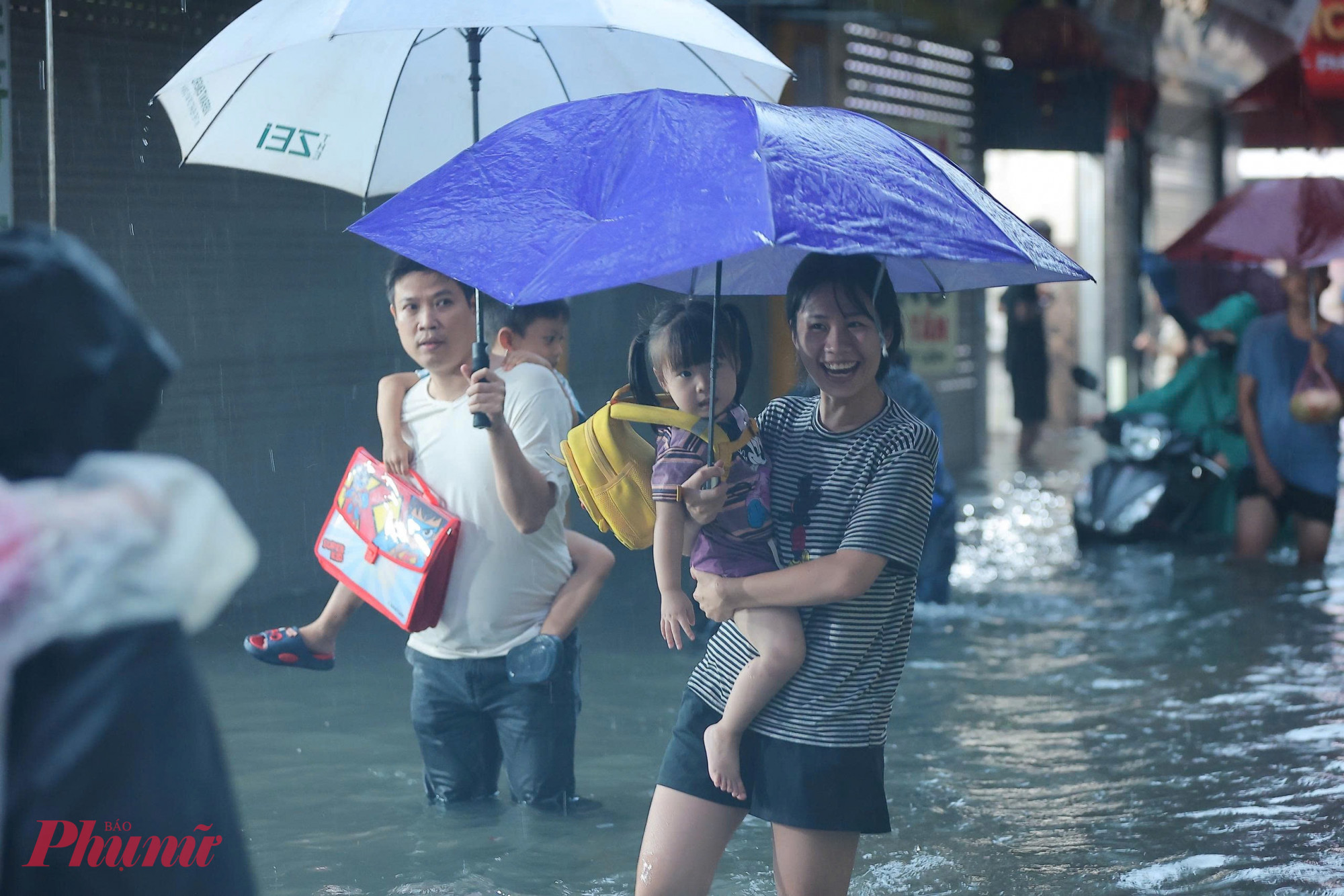 Người dân 'bơi' trên phố đi đón con, đi chợ vào thời điểm cuối ngày.