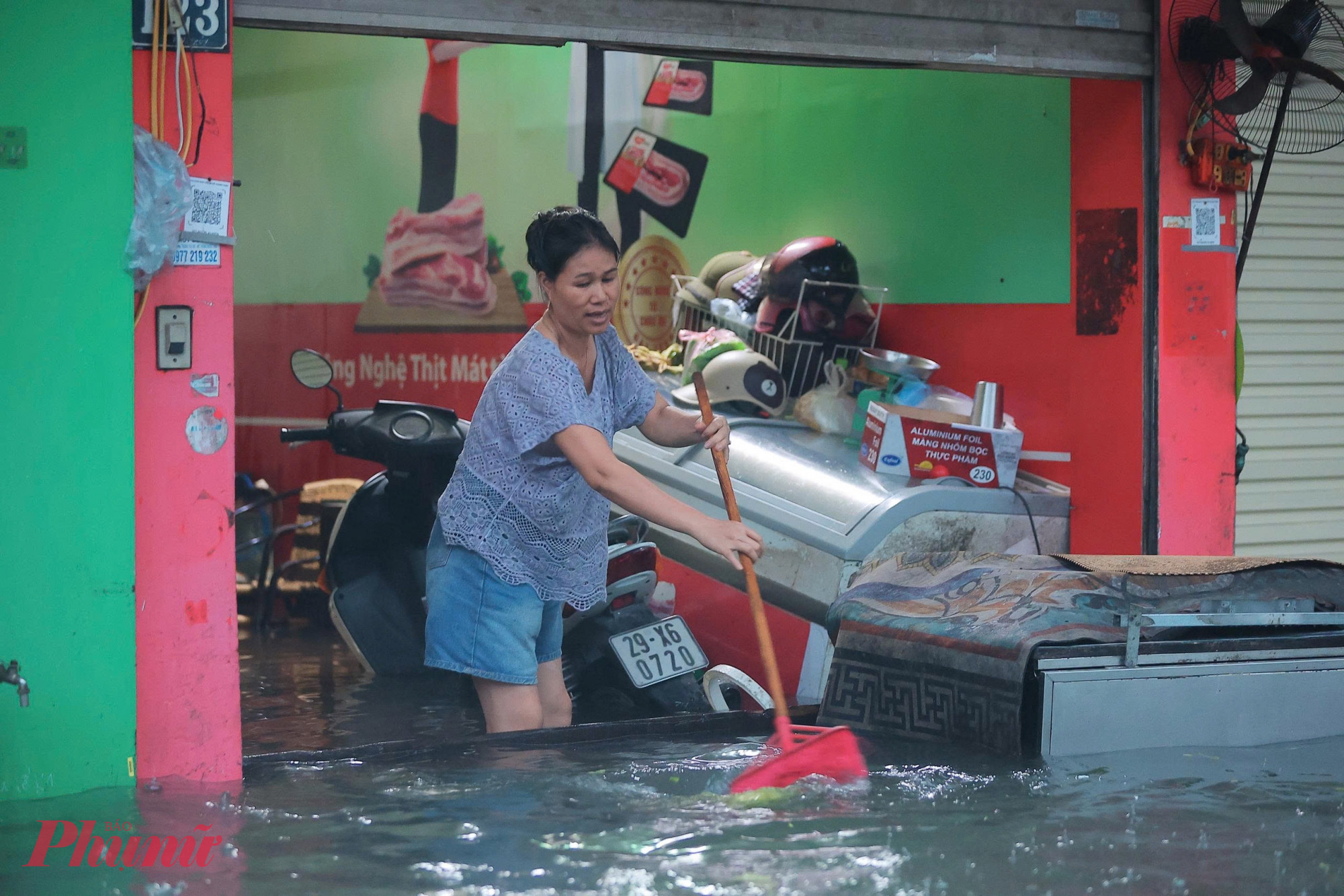 Dù người phụ nữ đã chặn cửa, liên tục quét nước ra, nhưng quét đến đâu nước lại tràn vào đến đấy.