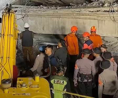 Nhân viên cứu hộ tìm kiếm người sống sót dưới đống đổ nát. Ảnh: CNA
