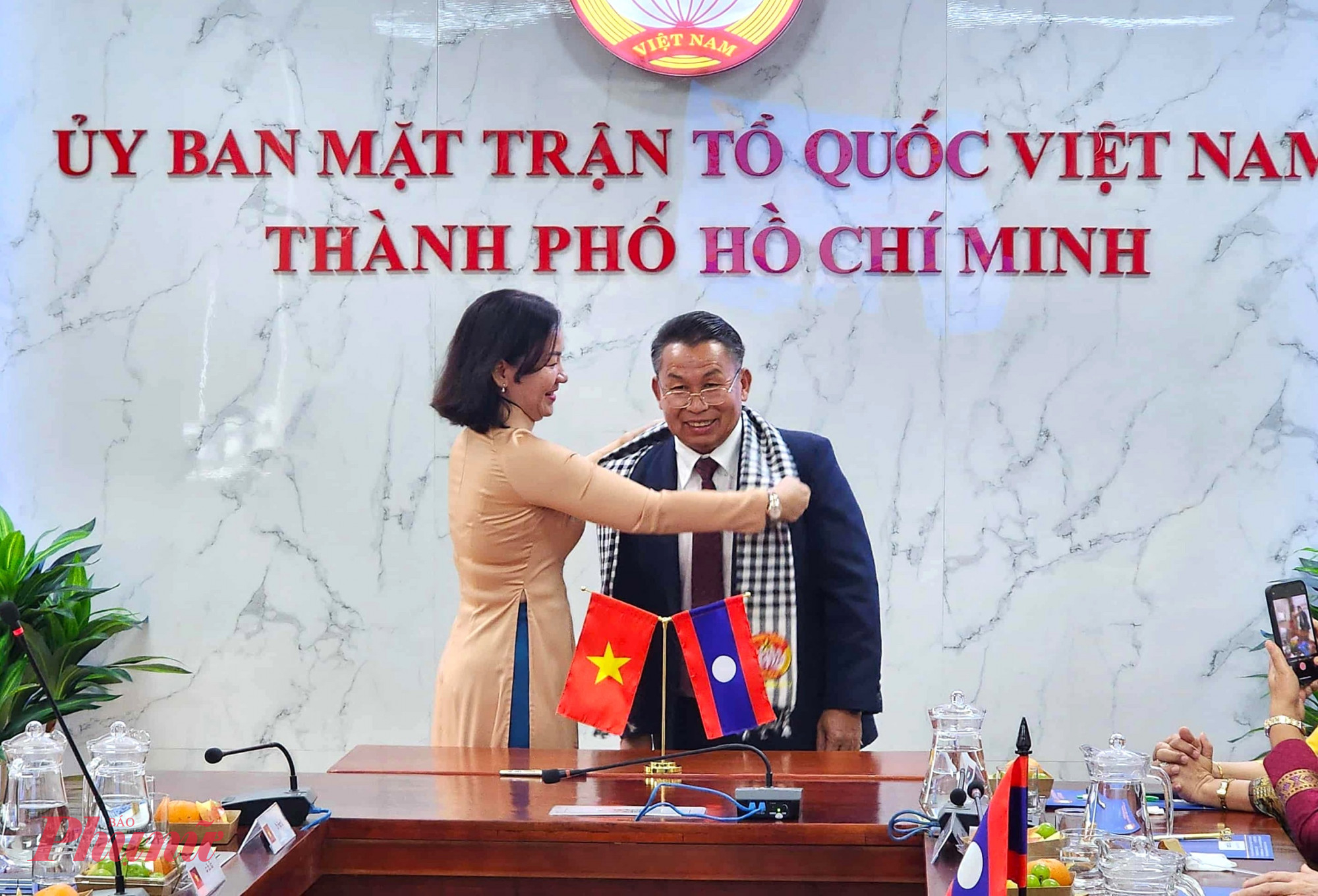 Bà Trương Thị Bích Hạnh gửi tặng chiếc khăn rằn truyền thống đến trưởng đoàn đại biểu Ủy ban Mặt trận Lào xây dựng đất nước thủ đô Viêng Chăn