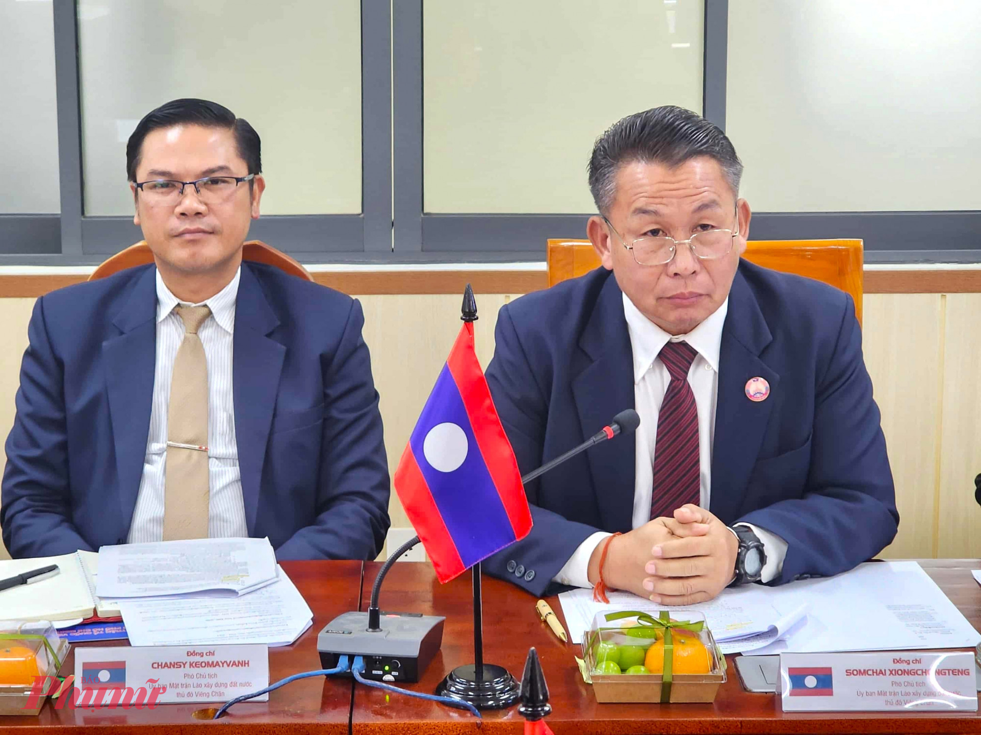 Ông Somchai Xiongchongteng (phải), Phó chủ tịch Ủy ban Mặt trận Lào xây dựng đất nước thủ đô Viêng Chăn, trưởng đoàn lắng nghe báo cáo về kết quả hợp tác giữa hai địa phương